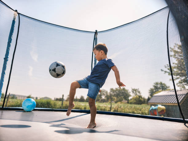 istock Mixed race boy enjoying trampoline  in summer 1666405258