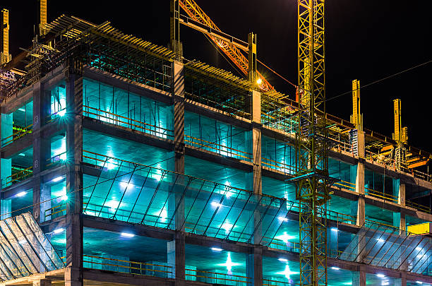 Construction at night with lights against the dark sky