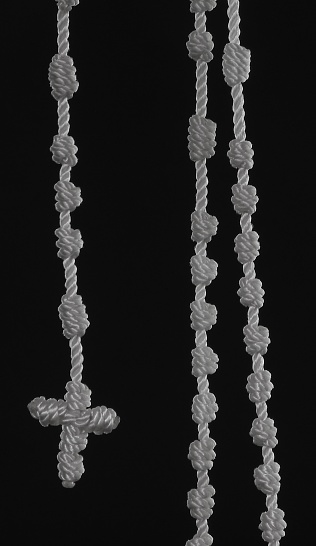 A knotted rosary dangling.
