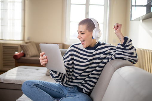 Young woman is relaxing at home listening to music