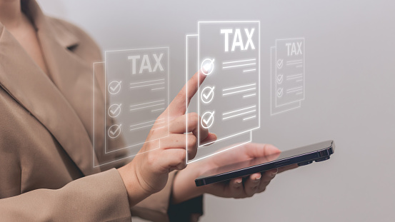 Tax payment concept. Businesswoman on blurred background using tablet pc.