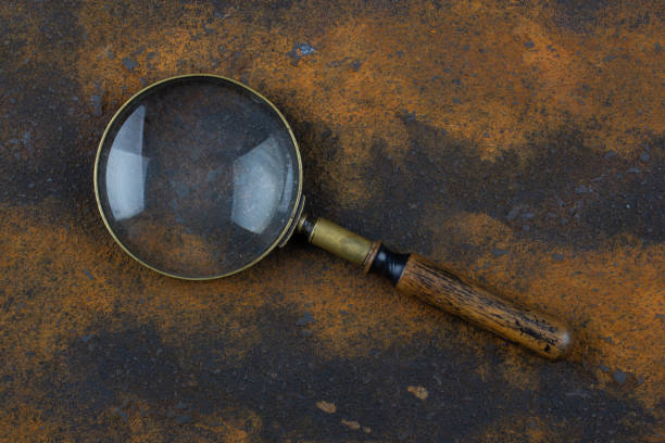 Vintage magnifying glass on metal rusty background,