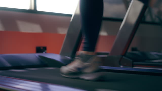 Close up shot of fitness female running on treadmill. Asian woman workout cardio and training at gym