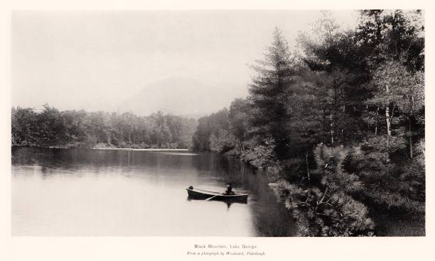 Rowboat on Lake George, New York State, United States, American Geography A man rows a boat on Lake George in the Adirondack Mountains, New York State, USA. Sepia-toned photograph engraving published 1896. This edition  is in my private collection. Copyright is in public domain. adirondack mountains stock illustrations