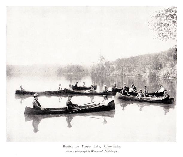 Canoes on Tupper Lake, Adirondack Mountains, New York State, United States, American Geography A group of people canoeing on Tupper Lake in the Adirondack Mountains, New York State, USA. Sepia-toned photograph engraving published 1896. This edition  is in my private collection. Copyright is in public domain. adirondack mountains stock illustrations