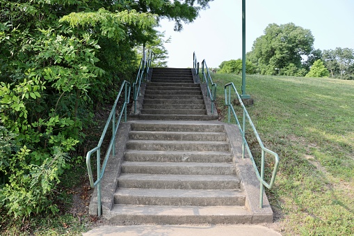 The cement steps up the hill in the park.