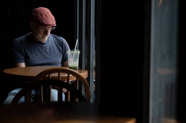 Caucasian man in a coffee shop against window