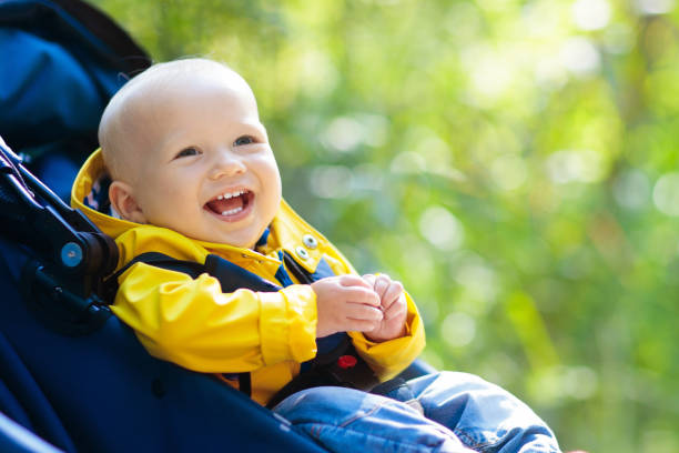 baby junge im kinderwagen im herbst park - gehen sportdisziplin stock-fotos und bilder