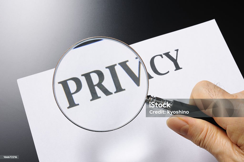 Tenendo una lente di ingrandimento alla ricerca di privacy - Foto stock royalty-free di Lente d'ingrandimento