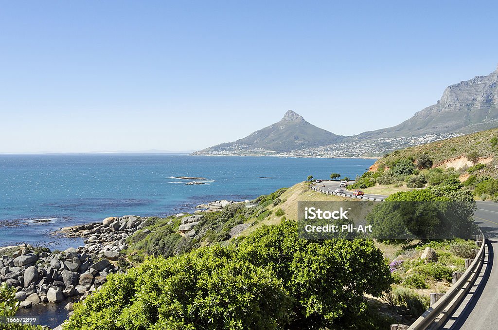 Driving along Cape Town's coastline Driving along the Atlantic Ocean towards Cape town. The mountain peak in the middle is Lion's Head with the settlement Camps Bay to the right. The mountain ridge leaving the frame is Table Mountain. Africa Stock Photo