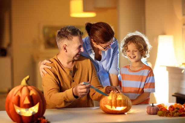 citrouille de sculpture de famille. astuce d’halloween ou de traiter - spider mum photos et images de collection