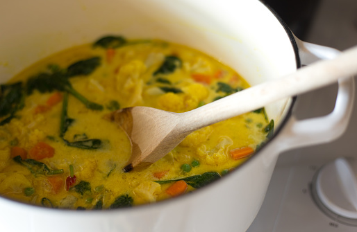 Vegetable Curry in White Pot with Wooden Spoon