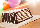 A layered chocolate cake with icing on a plate