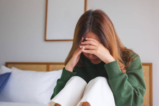 istock A woman sitting on the bed with feeling sad and stressed, sick and headache 1666767175