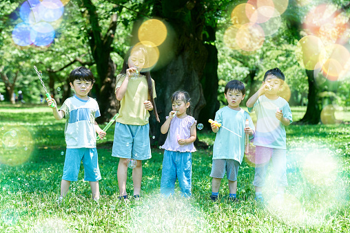 Children playing with soap bubbles at the park
