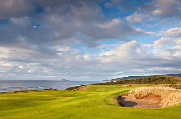 Beautiful Links Golf Course by the Sea A beautiful golf course by the ocean. Golf scenic. Horizon over water. Horizontal colour image. Copyspace and blue sky. Nova Scotia, Canada. cabot trail stock pictures, royalty-free photos & images