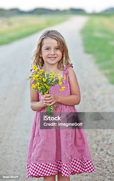 Menina Em Estrada De Cascalho Segurando Flores - Fotografias de stock e mais imagens de Ao Ar Livre - Ao Ar Livre, Beleza, Bronzeado