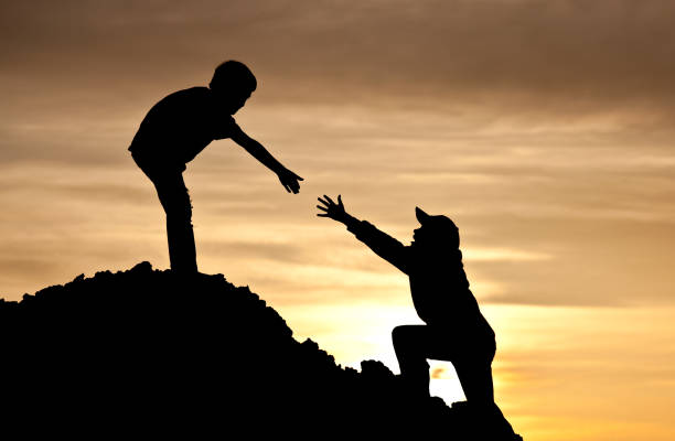 istock Boy Lending A Helping Hand to Friend Climbing 166678569