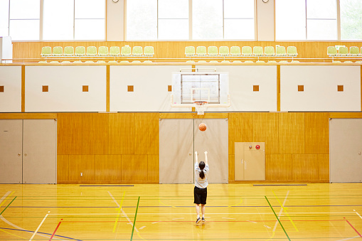 Japanese woman playing basketball in the gym