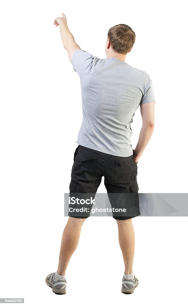 Vista traseira do homem bonito na t-shirt e short apontando - Foto de stock de Adulto royalty-free