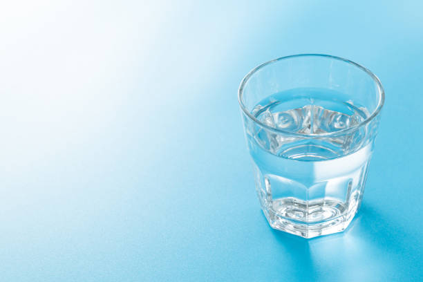 istock Glass of water on blue background. 1666822971