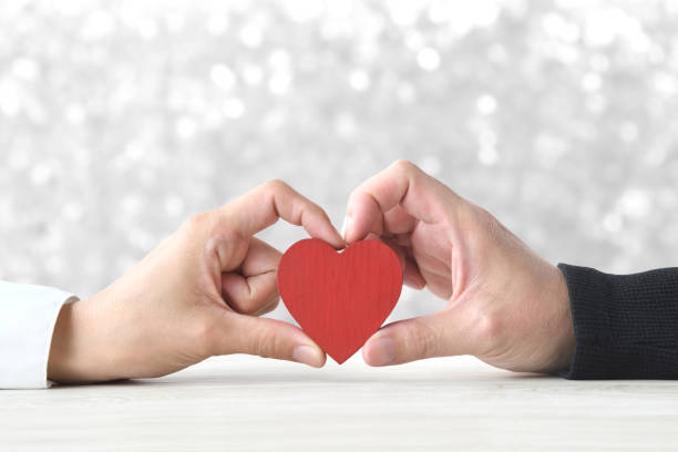 istock Heart object held by male and female hands 1666849111