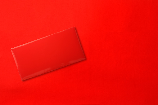 Overhead shot of red envelope on red background with copy space.