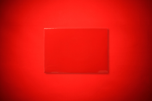 Overhead shot of red envelope on red background with copy space.