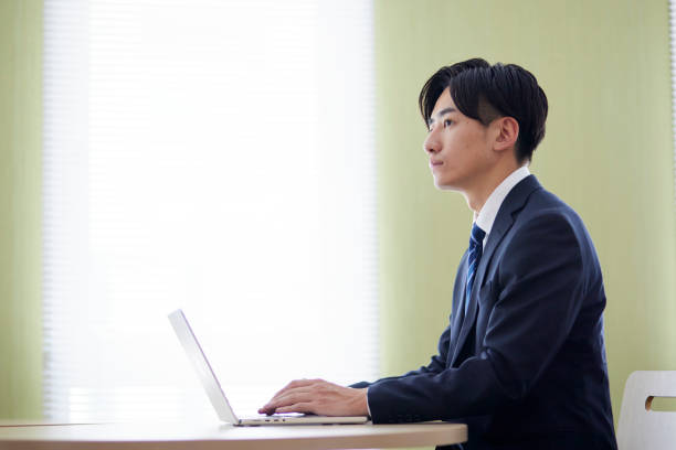 istock Japanese businessman wearing a suit working on a computer 1666867472