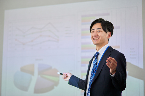 Japanese businessman wearing a suit giving a presentation