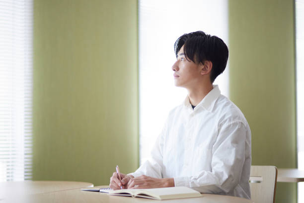 istock Japanese male university student studying in the university library 1666867559