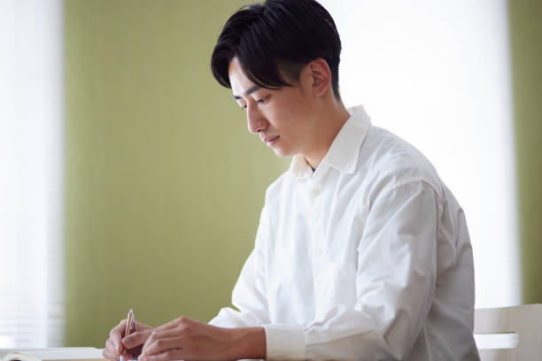 istock Japanese male university student studying in the university library 1666867585