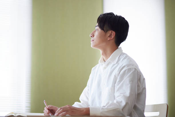 istock Japanese male university student studying in the university library 1666867640