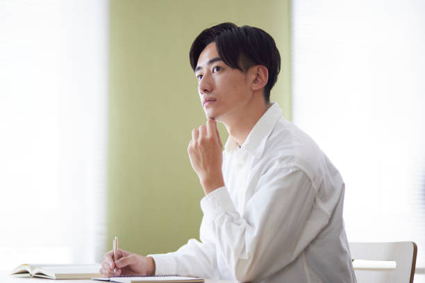 Japanese male university student studying in the university library