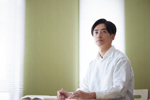 istock Japanese male university student studying in the university library 1666867648