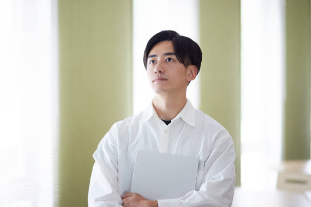 istock Japanese university student man with laptop in university library 1666867701