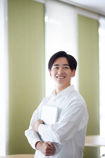 istock Japanese university student man with laptop in university library 1666867709