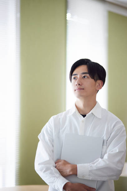 Japanese university student man with laptop in university library