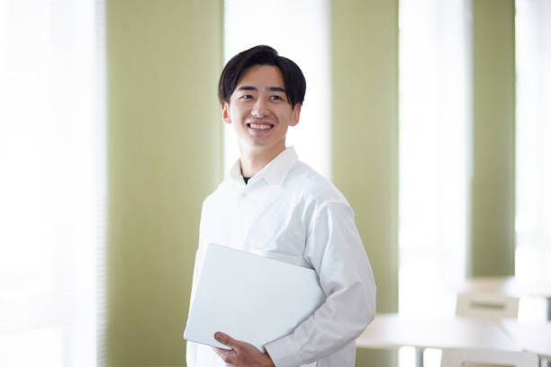 istock Japanese university student man with laptop in university library 1666867712