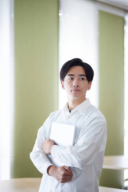 istock Japanese university student man with laptop in university library 1666867809