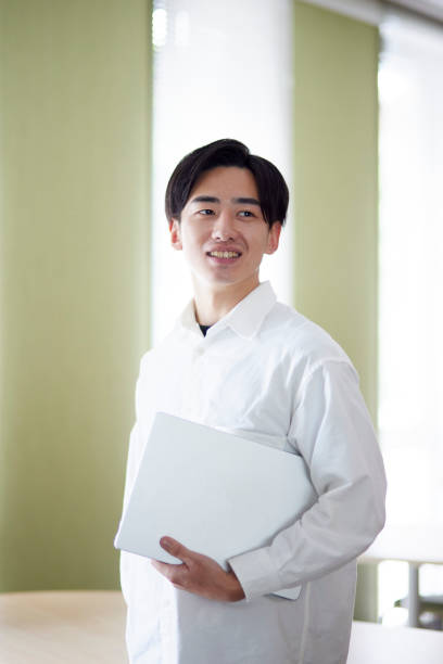 istock Japanese university student man with laptop in university library 1666867810