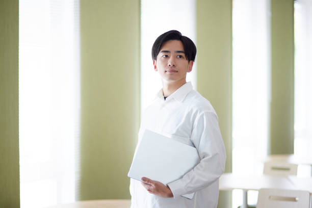 istock Japanese university student man with laptop in university library 1666867811