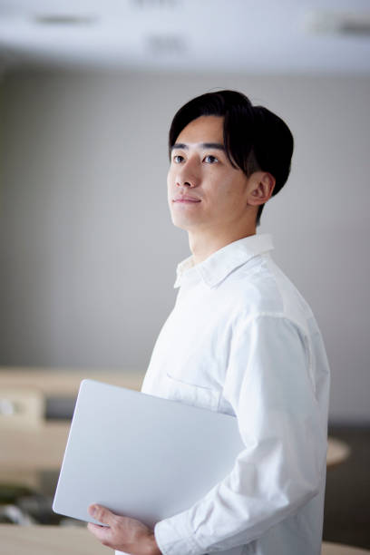 istock Japanese university student man with laptop in university library 1666867814