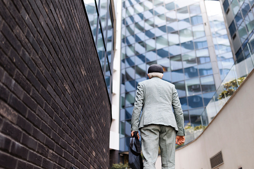 Back of senior businessman walking in the city