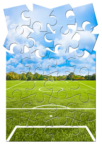 White lines of a soccer field against soft green grass - concept image in jigsaw puzzle shape