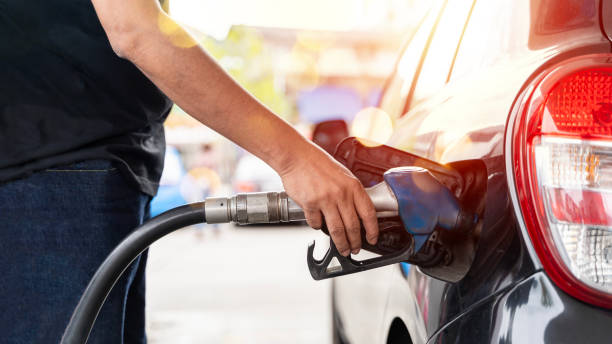 handyman fueling and refueling gas station oil gun in tank to fill pumping gasoline in a car at a gas station. - gas station gasoline refueling fuel pump imagens e fotografias de stock