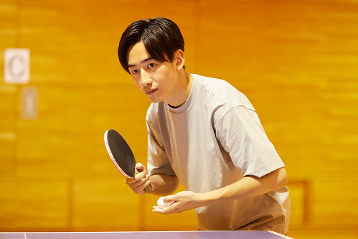 Shot of young businessmen playing table tennis at work. Games between employees during a work break