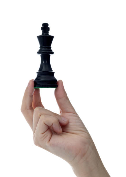 istock Human hand holding chess king on white background 1667000452