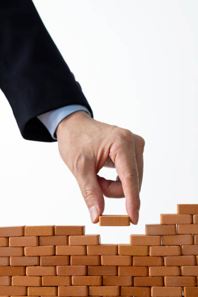 istock Businessman putting toy brick onto a wall 1667002721