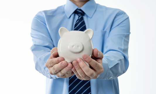 Businessman holding a piggy bank.